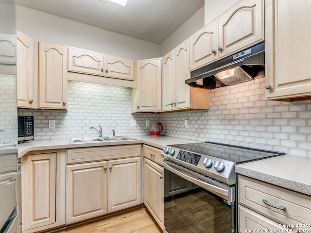 kitchen with light wood-type flooring, sink, stainless steel electric range, and tasteful backsplash