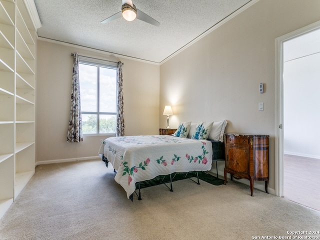 carpeted bedroom with a textured ceiling, crown molding, and ceiling fan