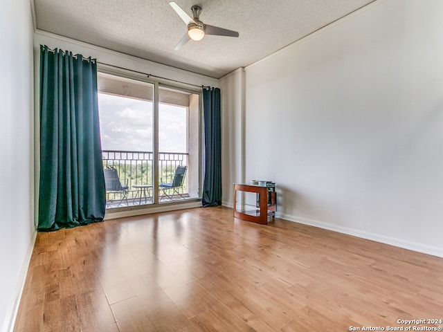 empty room with ceiling fan, a textured ceiling, and light hardwood / wood-style floors