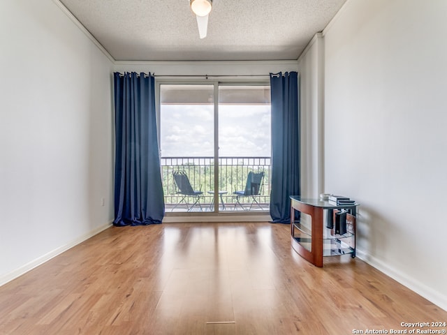 unfurnished room with ceiling fan, a textured ceiling, and hardwood / wood-style floors