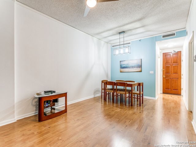 dining room with ceiling fan, a textured ceiling, and light wood-type flooring