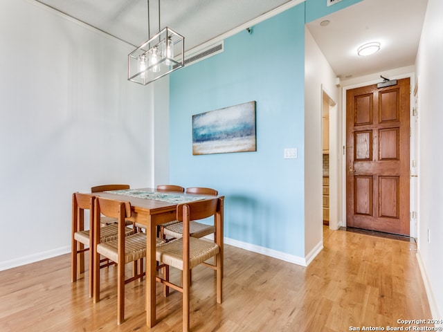 dining space featuring light hardwood / wood-style flooring and a chandelier