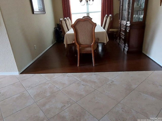 dining room with light wood-type flooring and a notable chandelier