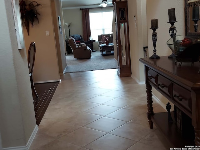 corridor with light tile patterned floors and ornamental molding