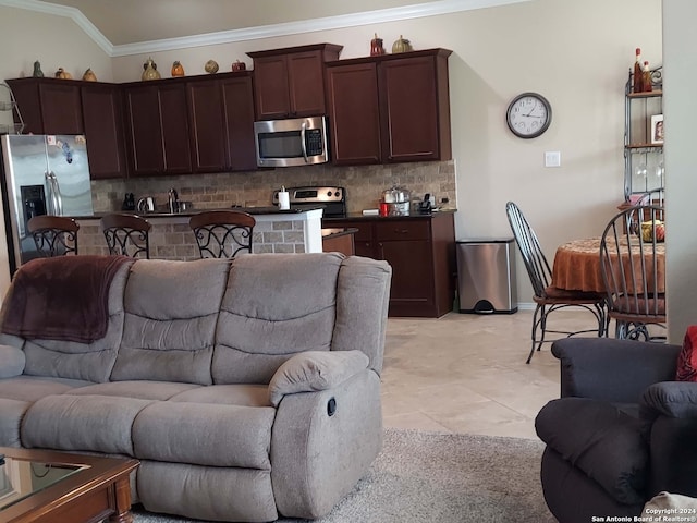 living room with light tile patterned floors, vaulted ceiling, ornamental molding, and sink