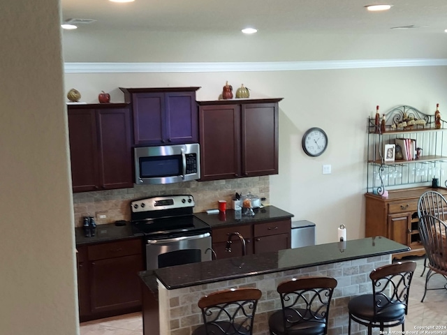 kitchen with appliances with stainless steel finishes, a center island, tasteful backsplash, and crown molding