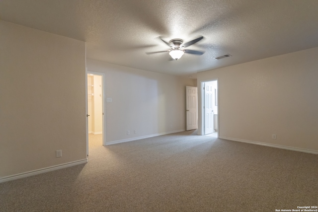 unfurnished room with ceiling fan, light colored carpet, and a textured ceiling