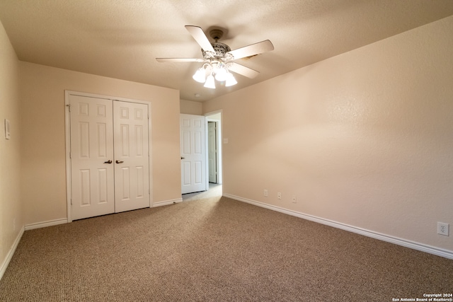 unfurnished bedroom with ceiling fan, a textured ceiling, a closet, and carpet flooring