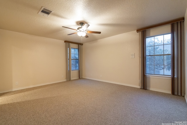 unfurnished room featuring a textured ceiling, carpet, and ceiling fan