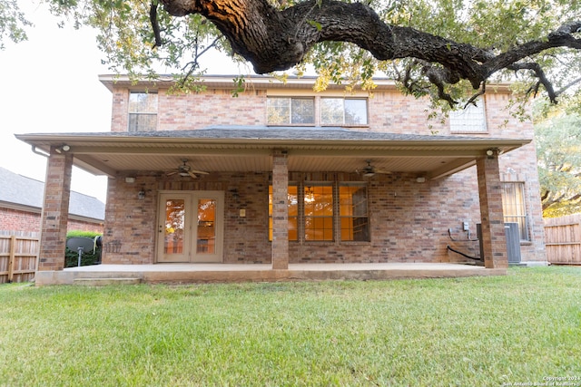 rear view of house featuring a lawn, ceiling fan, a patio area, and french doors