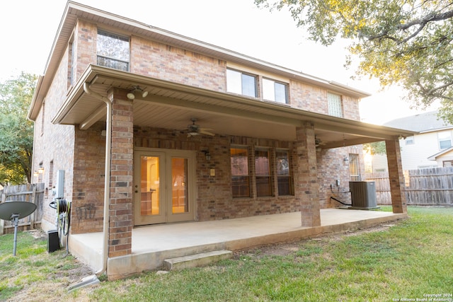 rear view of property featuring central AC, ceiling fan, a patio area, and a yard