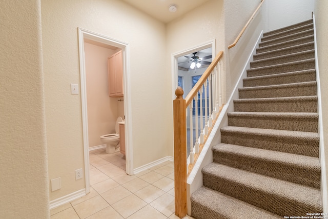 stairs with tile patterned flooring and ceiling fan