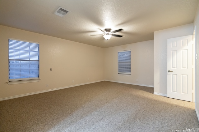 carpeted empty room with ceiling fan and a textured ceiling