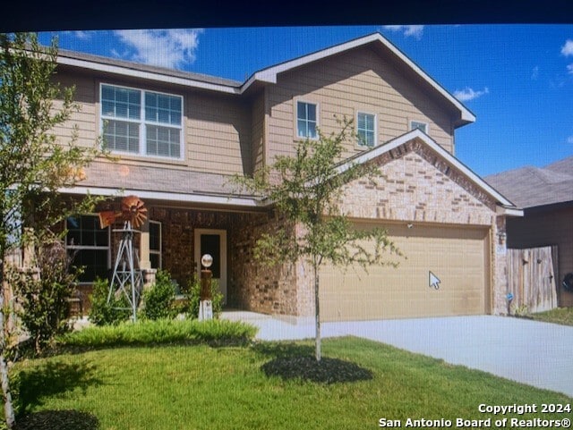 view of front of property featuring a garage and a front yard