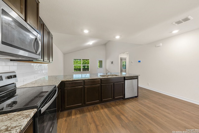 kitchen featuring appliances with stainless steel finishes, tasteful backsplash, light stone countertops, dark hardwood / wood-style flooring, and lofted ceiling