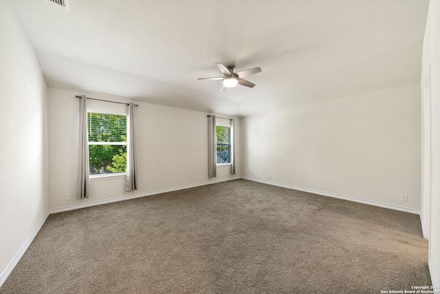 spare room featuring ceiling fan, carpet floors, and plenty of natural light