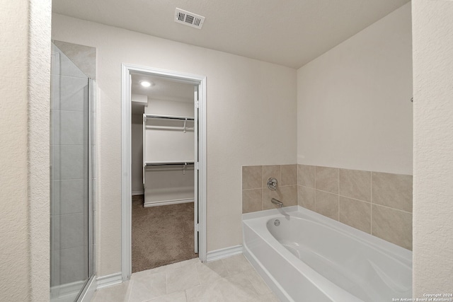 bathroom featuring separate shower and tub, a textured ceiling, and tile patterned floors