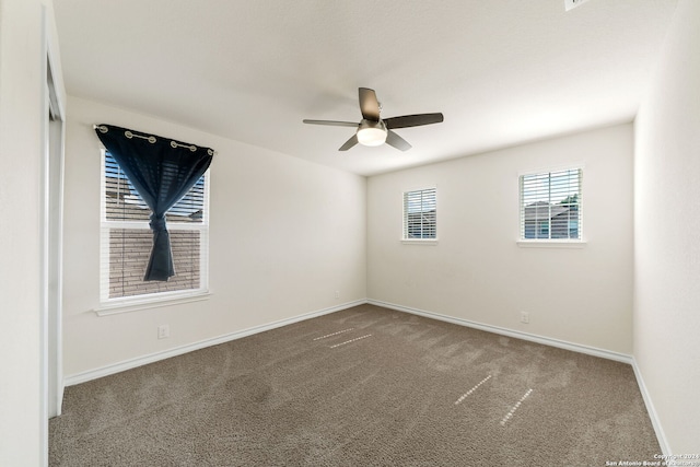 carpeted spare room featuring ceiling fan