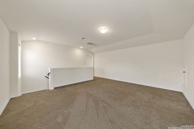 carpeted empty room featuring lofted ceiling