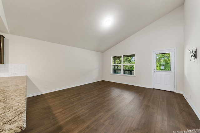 unfurnished living room featuring high vaulted ceiling and dark hardwood / wood-style floors