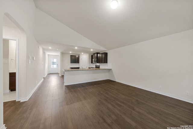 unfurnished living room with high vaulted ceiling and dark wood-type flooring