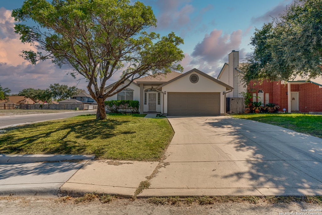 view of front of home with a front lawn and a garage