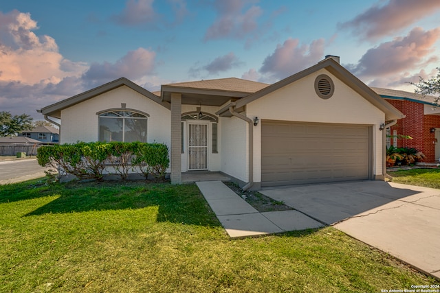 ranch-style house featuring a lawn and a garage