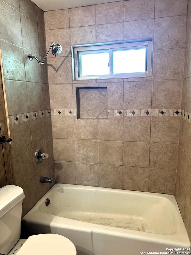 bathroom with tiled shower / bath and toilet