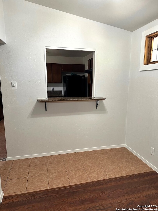 room details with black refrigerator and hardwood / wood-style floors