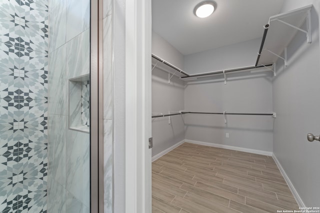 walk in closet with light wood-type flooring