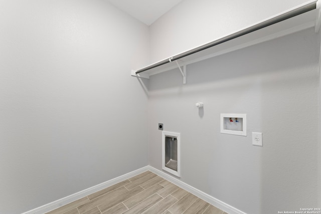 laundry room featuring washer hookup, hookup for an electric dryer, light hardwood / wood-style flooring, and gas dryer hookup