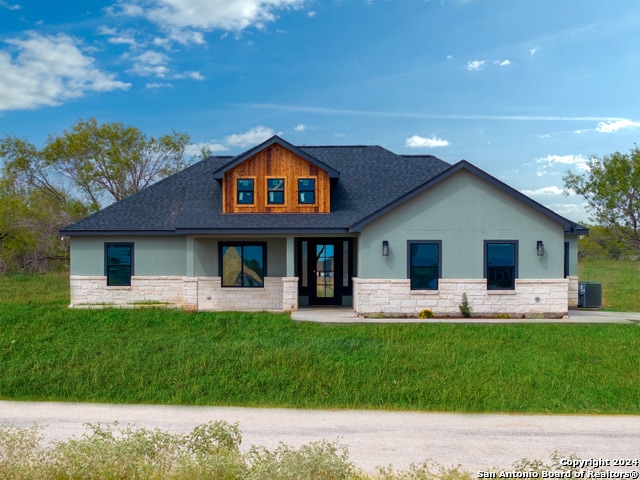 view of front of property with central air condition unit and a front yard