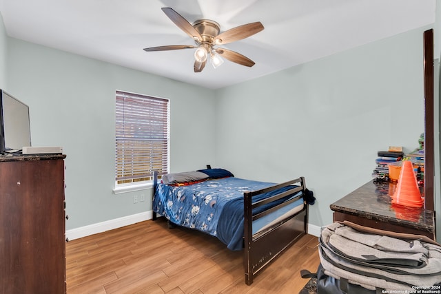 bedroom with light hardwood / wood-style floors and ceiling fan