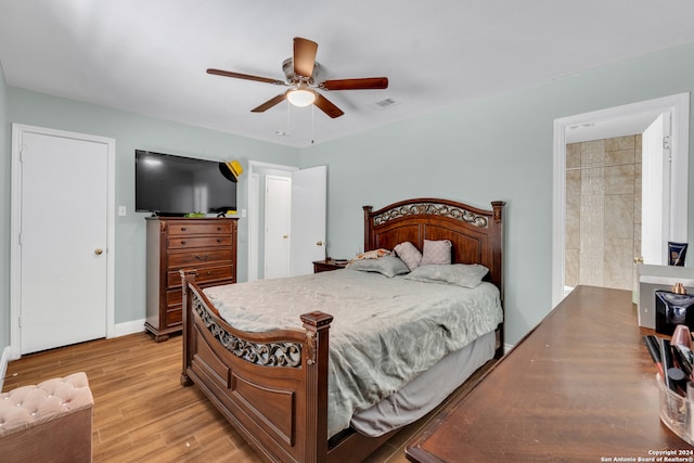 bedroom with light wood-type flooring, connected bathroom, and ceiling fan