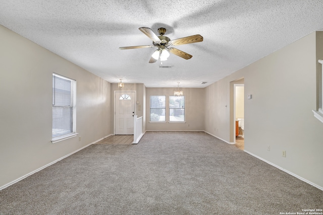 unfurnished living room with ceiling fan with notable chandelier, a textured ceiling, and light carpet