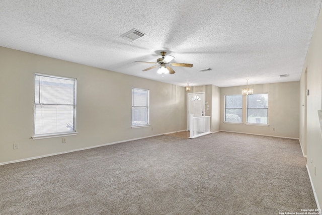 carpeted spare room with a textured ceiling and ceiling fan with notable chandelier