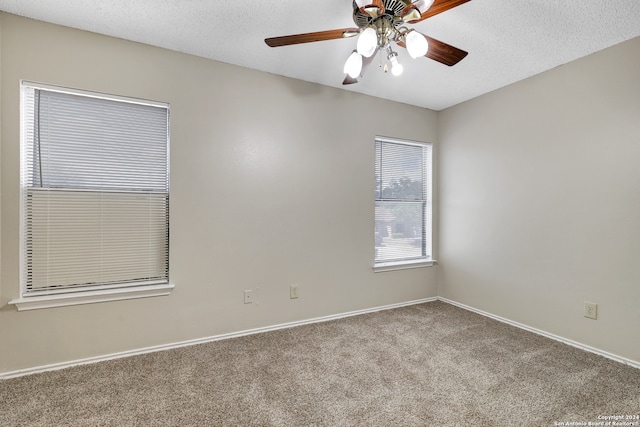 carpeted empty room with a textured ceiling and ceiling fan