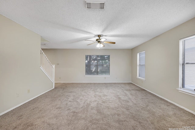 unfurnished room with ceiling fan, a textured ceiling, and carpet flooring