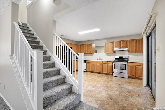 kitchen featuring light tile patterned floors, sink, a textured ceiling, dishwasher, and electric range