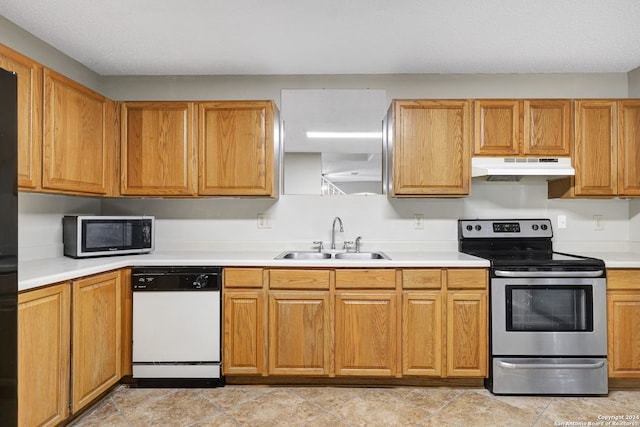 kitchen with appliances with stainless steel finishes, sink, and light tile patterned floors