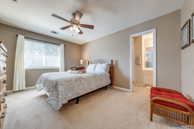 bedroom featuring light carpet, ceiling fan, and ensuite bathroom