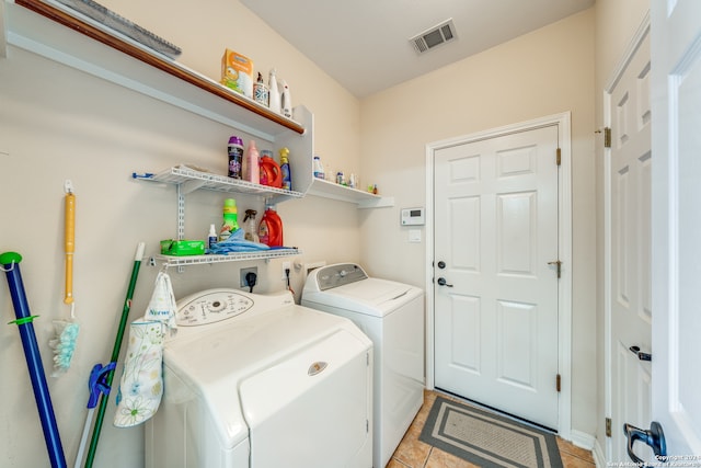 clothes washing area with light tile patterned flooring and washer and dryer