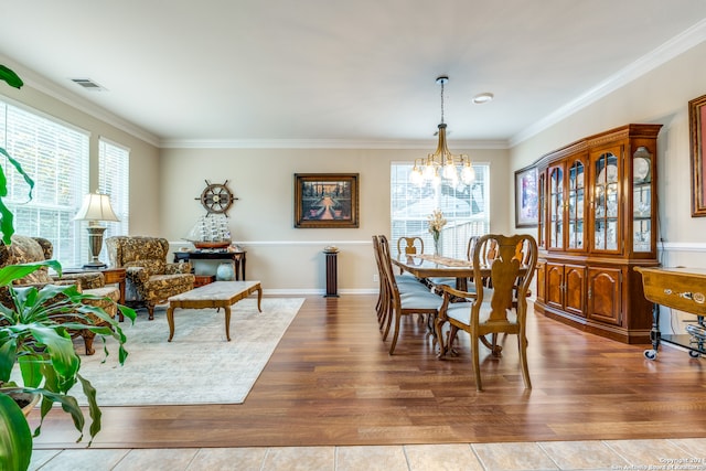 dining space with a chandelier, hardwood / wood-style flooring, and crown molding