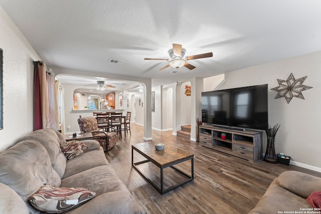 living room featuring a textured ceiling, ceiling fan, and hardwood / wood-style flooring