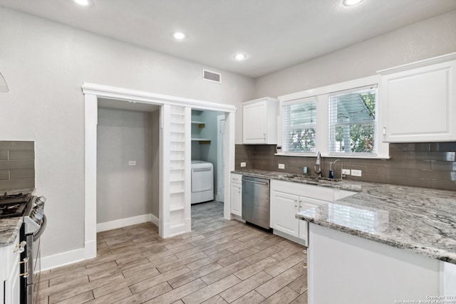 kitchen featuring washer / clothes dryer, sink, white cabinets, appliances with stainless steel finishes, and light stone countertops