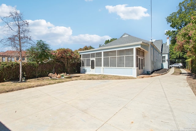 view of side of home with a sunroom and a patio area