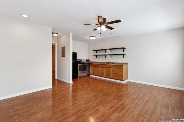 kitchen featuring electric panel, sink, stainless steel electric range oven, hardwood / wood-style floors, and ceiling fan