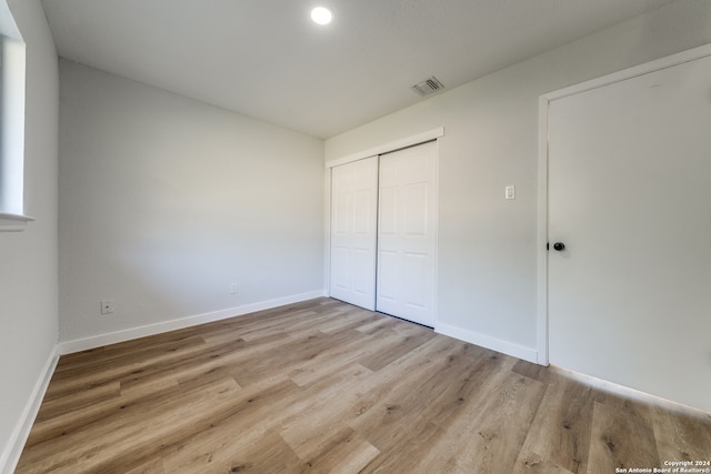 unfurnished bedroom featuring a closet and light hardwood / wood-style floors