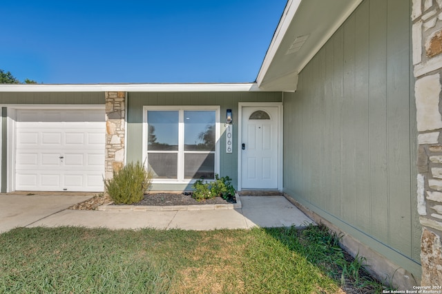 entrance to property with a yard and a garage