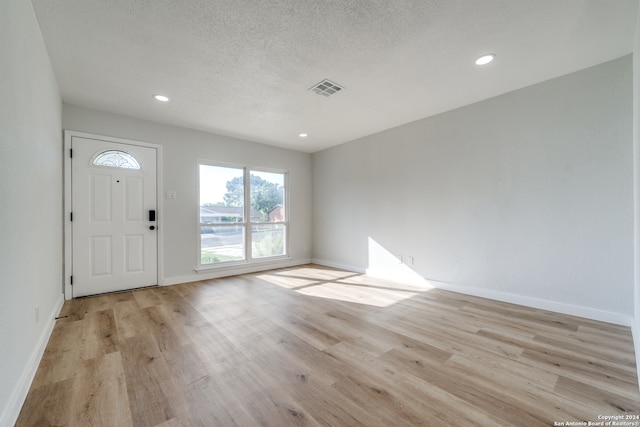 foyer featuring a textured ceiling and light hardwood / wood-style floors